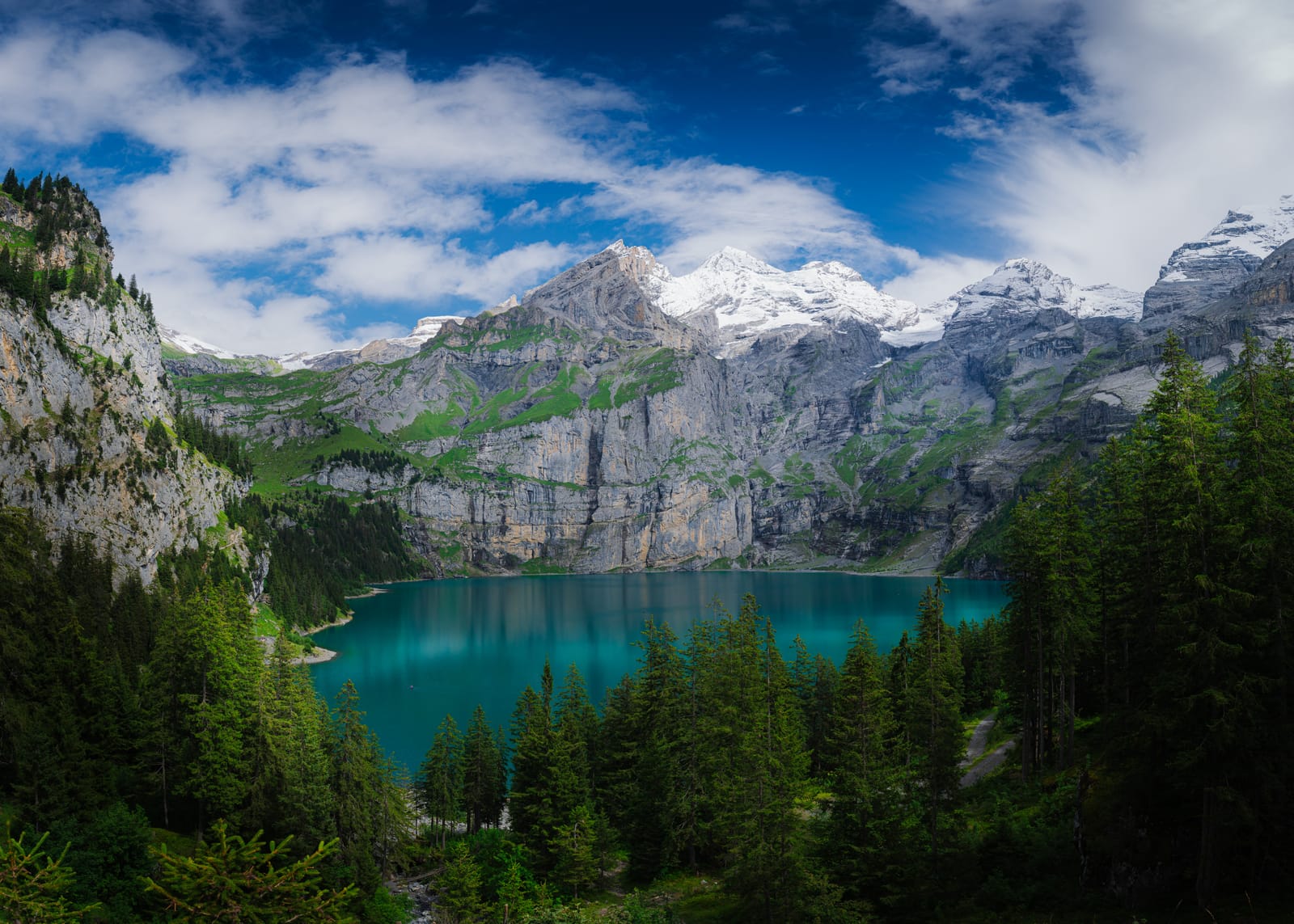 Turquoise alpine lake beneath snow peaks.